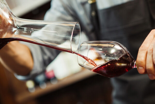Sommelier versant du vin dans un verre à partir d'un décanteur à vin.