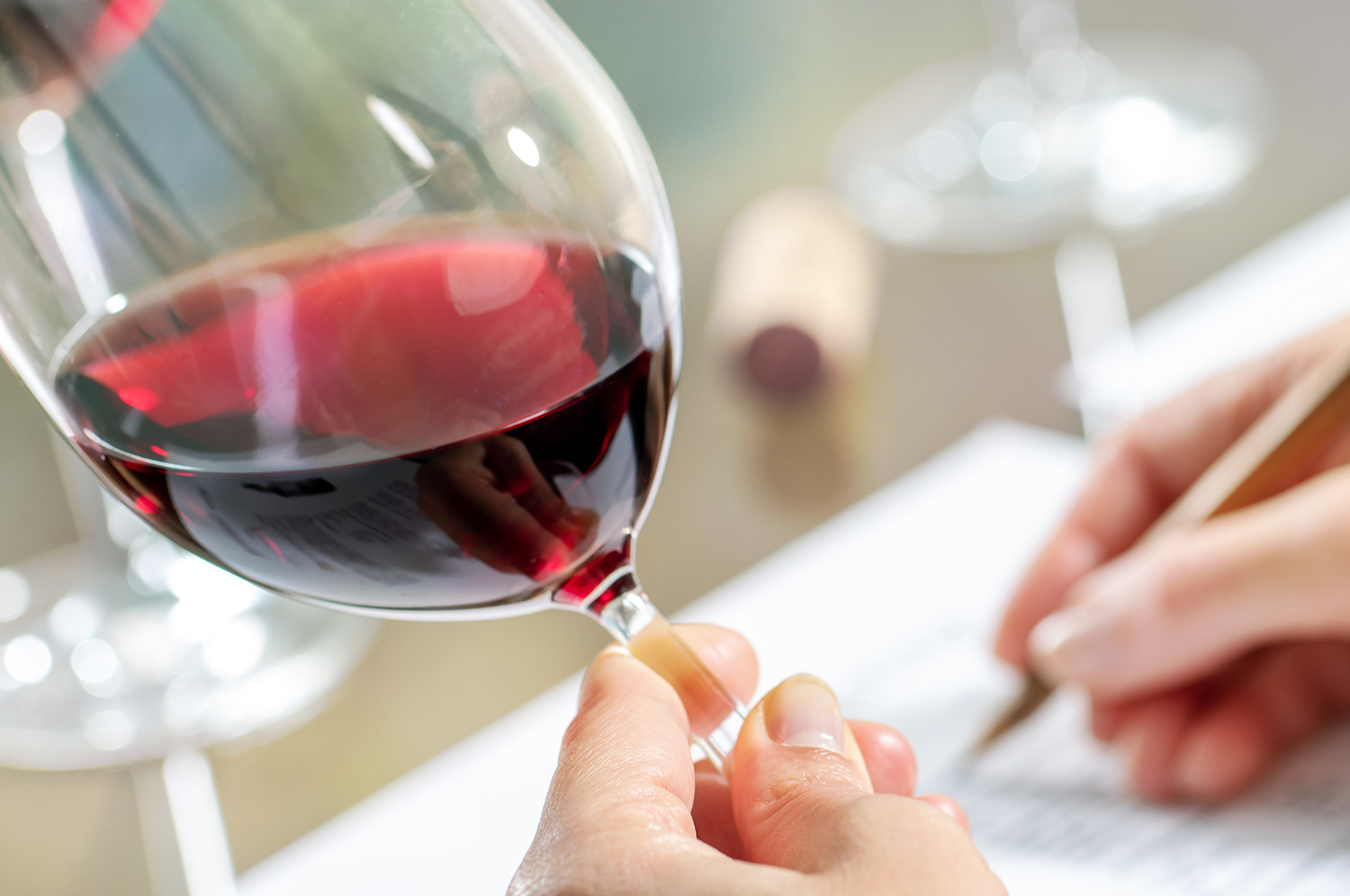 Main tenant un verre de vin rouge